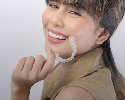 smiling woman is holding an invisalign bracer stock image